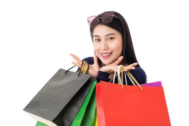 Beyaz arka planda gülen yüzlü, alışveriş torbaları tutan genç, mutlu Asyalı kadın..