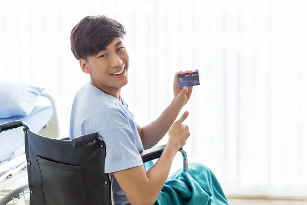 Νεαρός Έφηβος Ασιάτης Που Κρατά Πιστωτική Κάρτα Κάθεται Στην Αναπηρική — Φωτογραφία Αρχείου