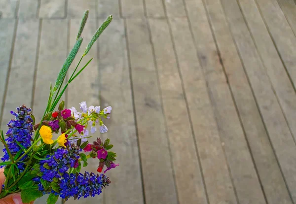 Bouquet of wildflowers on a background of wooden boards. Copy space.