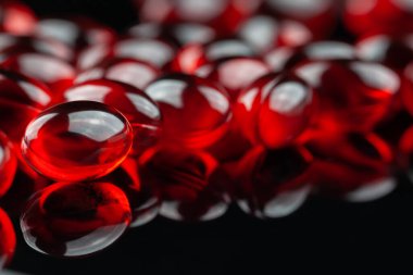 Siyah arka planda kırmızı tıbbi kapsüller.