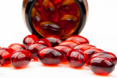 Kırmızı jel tıbbi kapsüller, beyaz arka planda izole edilmiş..