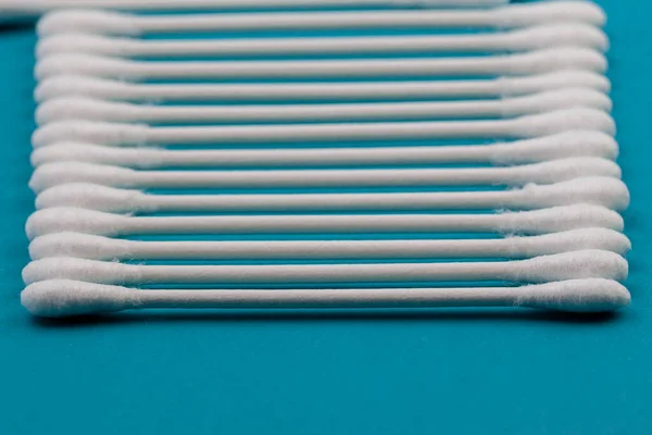 Q-tips, cotton swabs, isolated on bright blue background.