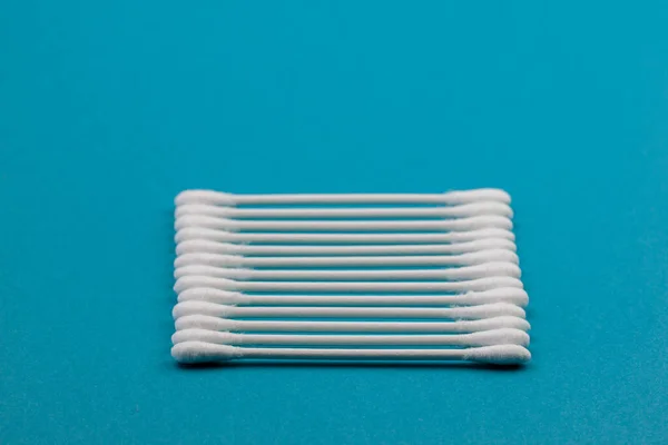 Q-tips, cotton swabs, isolated on bright blue background.