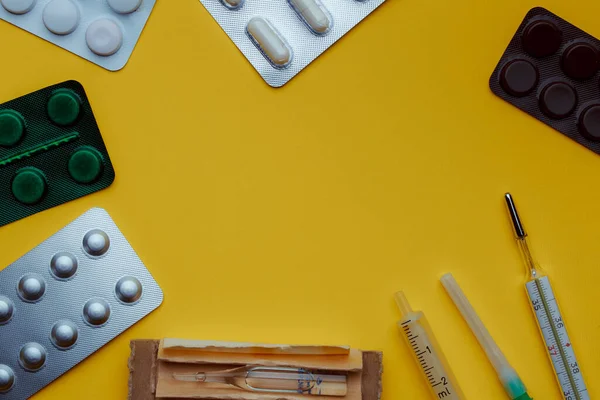 Pills for the treatment of viral infection. Medication on a yellow background. Medicines for personal care. Headache remedy. Safe workplace. Concept covid19.