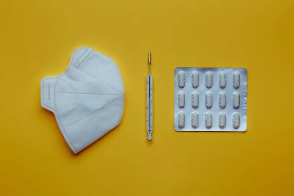 Pills for the treatment of viral infection. Medication on a yellow background. Medicines for personal care. Headache remedy. Safe workplace. Concept covid19.