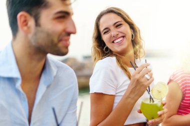 Gençler bar masasında sohbet edip kokteyl içerek eğleniyorlar. Yaşam tarzı gençlik kavramı 