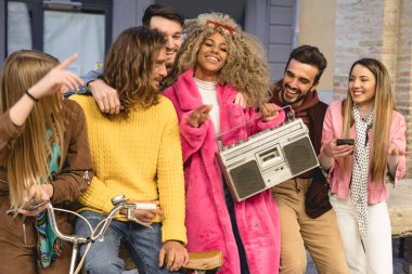Bir grup modaya uygun arkadaş akıllı telefonlarıyla bir video bloğu çekiyor. Dengeleyiciye monte edilmiş. Eski bir kasetçalarda dans edip müzik dinleyerek eğleniyorum.