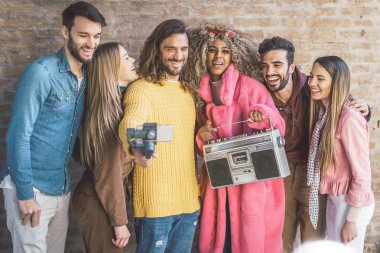 Bir grup modaya uygun arkadaş akıllı telefonlarıyla bir video bloğu çekiyor. Dengeleyiciye monte edilmiş. Eski bir kasetçalarda dans edip müzik dinleyerek eğleniyorum.