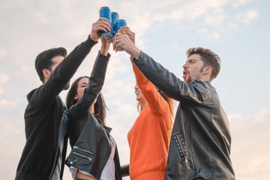 Bir grup genç dışarıda bira içiyor.