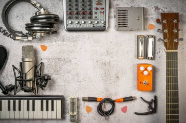 Şarkıcı-söz yazarı ve evde kayıt, yaşam tarzı müzik konsepti. Müzisyen, ses mühendisi, gitar, mikser, mikrofon, klavye, kablo, kulaklık gibi şeylerle yatıyordu. Vintage filtrelenmiş