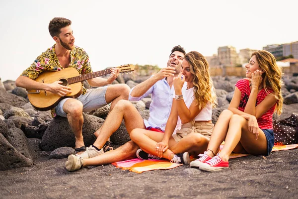 Bir Grup Genç Arkadaş Sahilde Gitar Çalarak Gün Batımında Şarkı — Stok fotoğraf