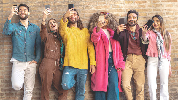 Группа мультикультурных друзей, использующих смартфон на открытом воздухе против стены перерыва - Люди, зависимые от мобильного смартфона - Технологии и социальные медиа концепция с подключенными мужчинами и женщинами

