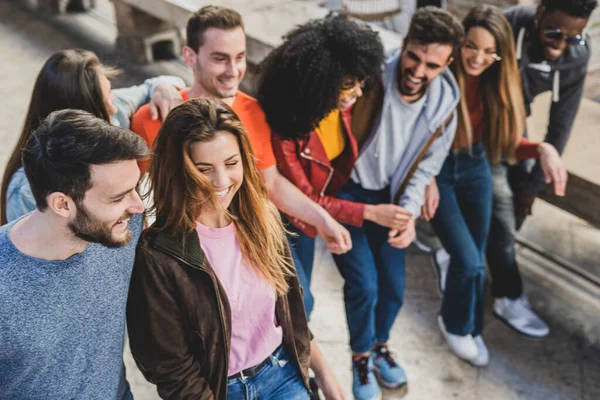 Birliktelik ve birliktelik kavramı, çok ırklı gençlerin birbirini kucaklaması. Farklı ırktan arkadaşlar sokakta omuz omuza yürüyorlar..