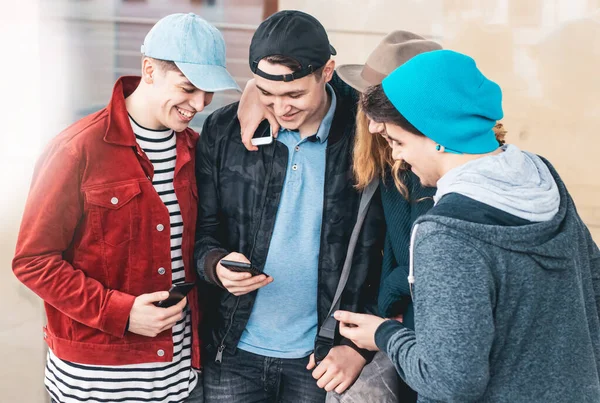 Akıllı telefonlarını izleyen bir grup genç eğleniyor. Gençler dışarıda yeni teknolojiler ve sosyal medya kullanıyorlar..