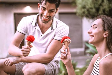 Bir bankta oturmuş dondurma yiyen iki genç aşık. Boş zaman aktiviteleri yaşam tarzı konsepti