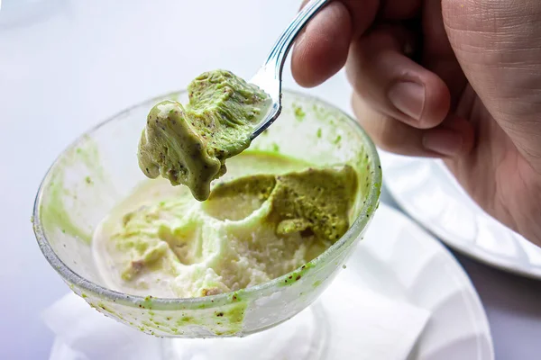 Hands holding a spoon with almond and pistachio \