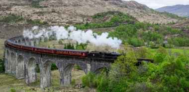 Glenfinnan Viaduct, İskoçya. Avrupa 'da seyahat / turizm merkezi. Eski tarihi buhar treni film sahnesinde, ünlü viyadük köprüsünde. Dağlar, dağlar, dış plan.