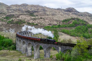 Glenfinnan Viaduct, İskoçya. Avrupa 'da seyahat / turizm merkezi. Eski tarihi buhar treni film sahnesinde, ünlü viyadük köprüsünde. Dağlar, dağlar, dış plan.