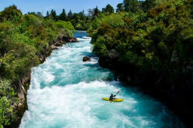 Yeni Zelanda 'ya git. Taupo Gölü, Kuzey Adası 'ndaki Huka Şelaleleri' nin en popüler turistik mekanı. Beyaz ve turkuaz su, arka planda yeşil orman. Güzel manzara manzarası. Aktif yaz tatili. 