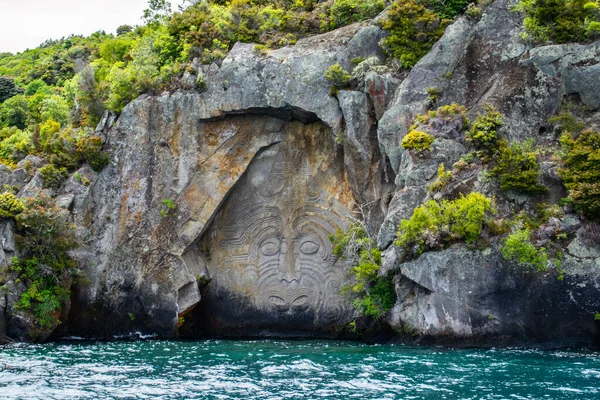 Yeni Zelanda 'yı, Kuzey Adası' nı, Taupo 'yu dolaş. Büyük Taupo Gölü 'ndeki kayada oyulmuş Iconic Maori kayası manzarası. Popüler turistik ilgi / etkinlik.