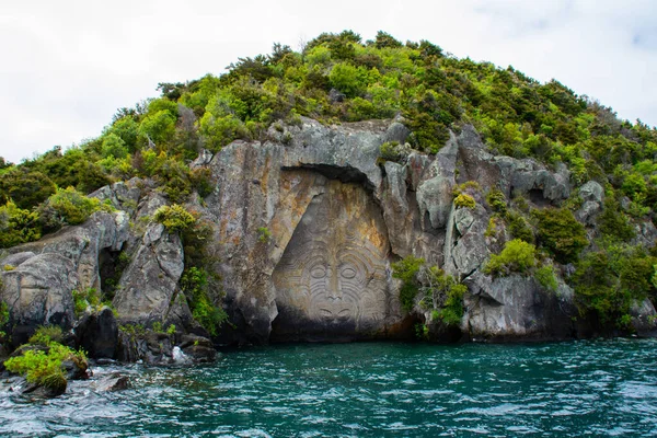 Yeni Zelanda 'yı, Kuzey Adası' nı, Taupo 'yu dolaş. Büyük Taupo Gölü 'ndeki kayada oyulmuş Iconic Maori kayası manzarası. Popüler turistik ilgi / etkinlik.