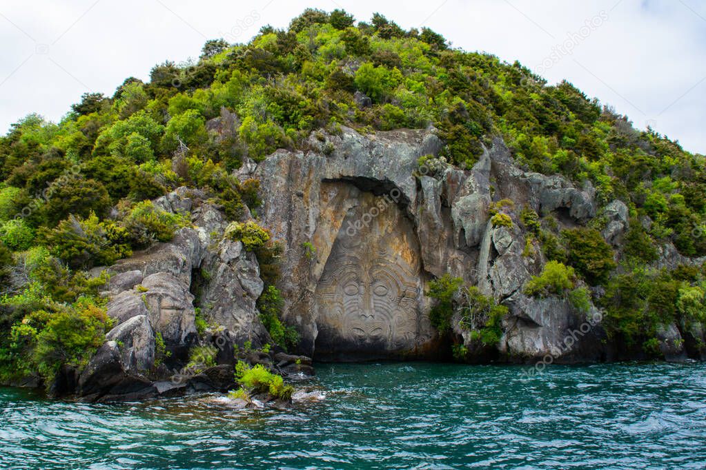 Travel New Zealand, North Island, Taupo. Cruise view of Iconic Maori rock carving in the rock on Great Lake Taupo. Popular tourist attraction/activity.