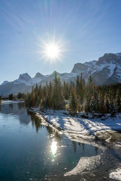 Canada Landscape. View of snow covered mountain scenery, Bow river and Three Sisters in winter. Beautiful sunny day in Canadian Rockies. Canmore, Alberta, Canada.