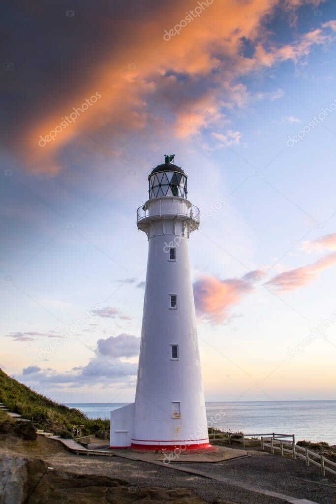 Panoramic scenic landscape view of the Castlepoint lighthouse in sunrise colours, white landmark, tourist popular attraction/destination in North Island, New Zealand. 