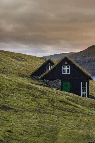 Vagar Adası 'nda çimen (çim) çatılı geleneksel tarihi ahşap ev / bina manzarası. Faroe Adaları 'nda (Danimarka) turist popülerliği)