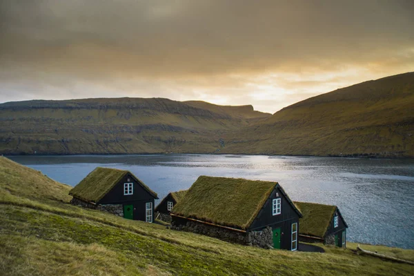 Vagar Adası 'nda çimen (çim) çatılı geleneksel tarihi ahşap ev / bina manzarası. Faroe Adaları 'nda (Danimarka) turist popülerliği)