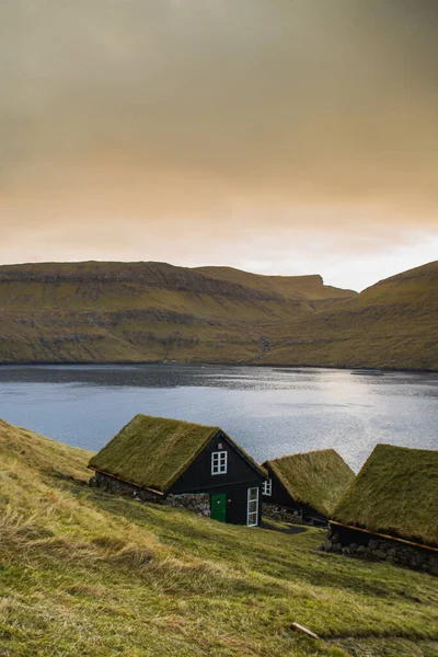 Vagar Adası 'nda çimen (çim) çatılı geleneksel tarihi ahşap ev / bina manzarası. Faroe Adaları 'nda (Danimarka) turist popülerliği)
