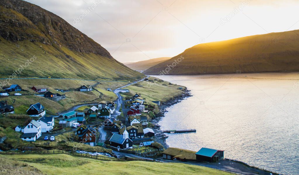 Scenic landscape view of traditional historic stone wooden houses/buildings with grass (turf) roof in the village, Vgar Island. Tourist popular attraction/place in Faroe Islands (Denmark)