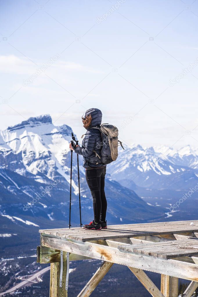 Active hiker women overlooking Canadian Rockies from the helipad at Lady MacDonald hiking trail, Canmore, Alberta, Canada