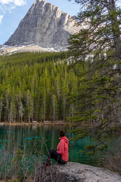 Grassi Gölü, Canmore, Alberta, Kanada manzaralı kırmızı ceketli yürüyüşçü / turist kadın.