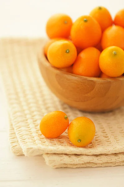 Fresh juicy natural kumquats in a wooden bowl — ストック写真