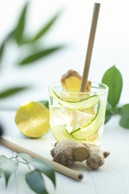 Bir bardak zencefilli su ve bambu kokteyl tüpü.