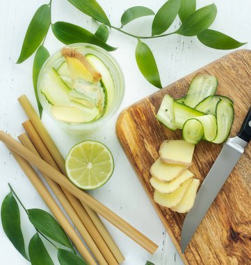 preparation of ginger water for weight loss from ginger, water, lime and cucumber clipart
