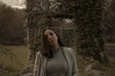 Rüzgâr saçlarını savururken kız bitkilerden oluşan bir parkta