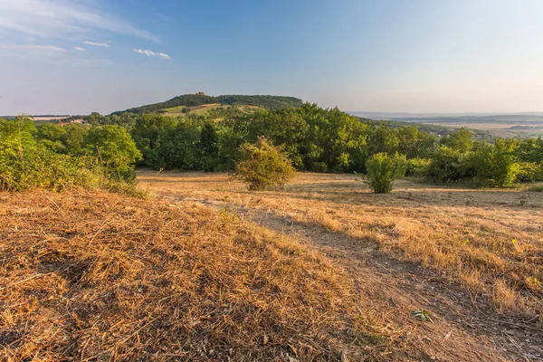 Ön planda bir yol ve t tepelerde ile kırsal manzara — Stok fotoğraf