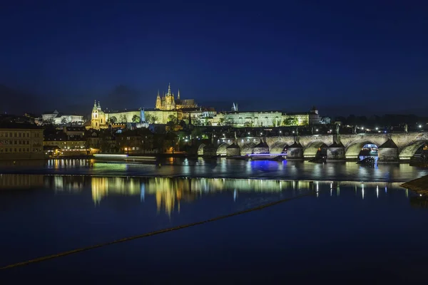 Prag Kalesi ve Charles Köprüsü gece, mavi gökyüzü ve nehir, C — Stok fotoğraf