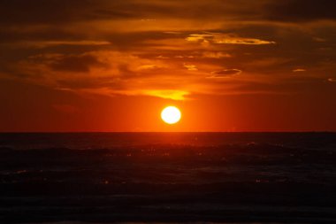 Rivazzurra 'da (Rimini / İtalya) okyanus gündoğumu sırasında dramatik turuncu bulutlar