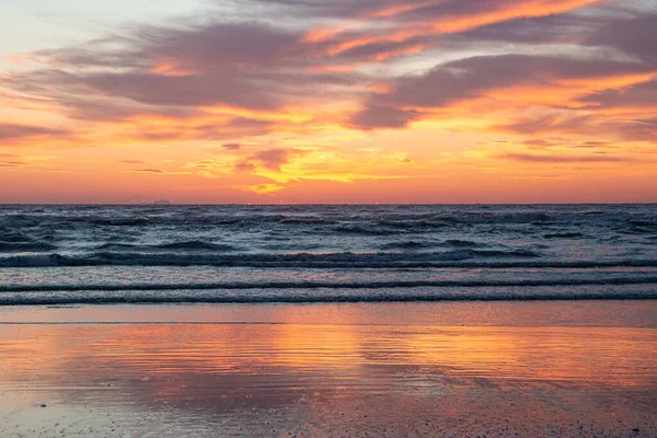dramatic orange clouds during ocean sunrise at Rimini beach (Italy); inspirational motivational positive new beginning concept