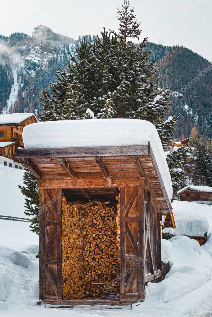 snow covered traditional firewood hut in St. Gertraud (Ultental,South Tyrol/Italy) on cold winter day 