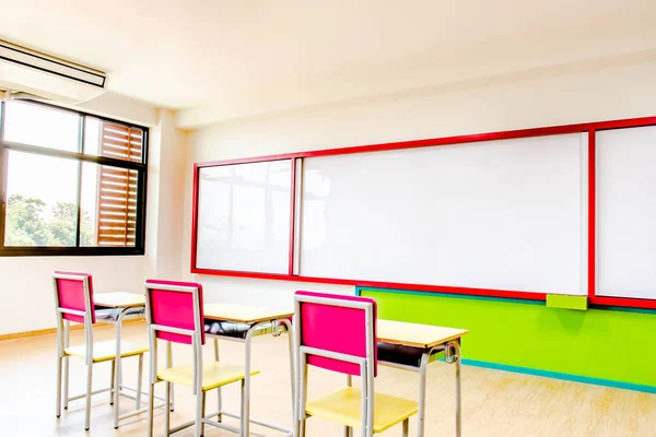 Secretárias, cadeiras e prancha branca na sala de aula do jardim de infância . — Fotografia de Stock