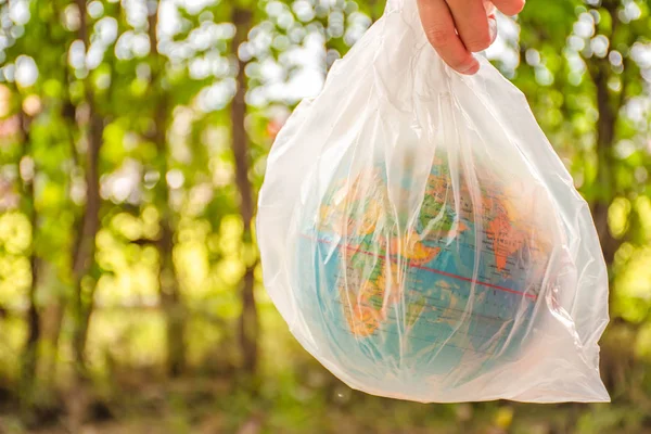 El, dünya modelini plastik bir çantada tutuyor..
