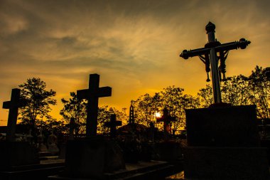 Gün batımında bir Katolik mezarlığının silueti..