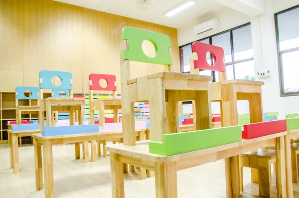 Schreibtische und Stühle im Klassenzimmer des Kindergartens. — Stockfoto