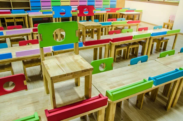 Schreibtische und Stühle im Klassenzimmer des Kindergartens. — Stockfoto