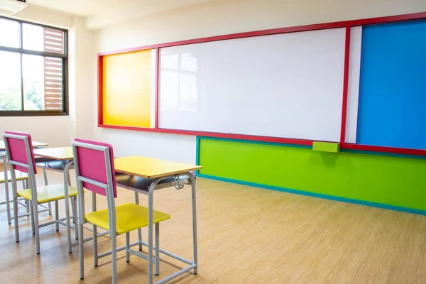 Schreibtische, Stühle und Whiteboard im Klassenzimmer des Kindergartens. — Stockfoto