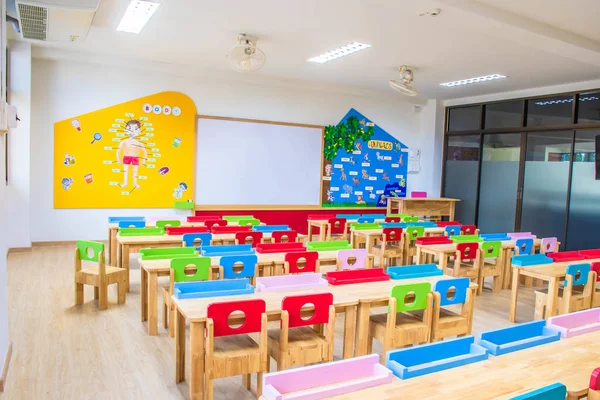 Schreibtische, Stühle und weiße Tafeln im Klassenzimmer des Kindergartens. und — Stockfoto